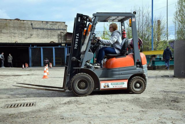 Uczeń jadący wóżkiem widłowym przez plac