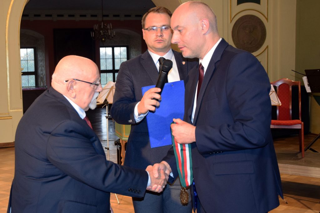 Wojewoda Opolski Adrian Czubak wręcza Pawłowi Kozerskiemu medal Gloria Artis
