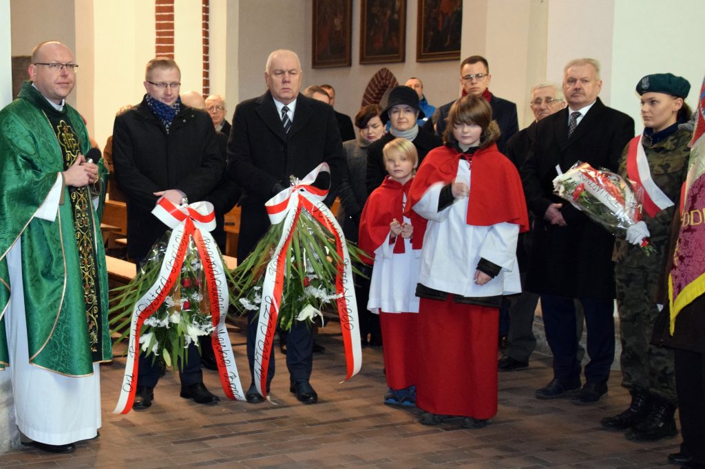 Starosta Maciej Stefański i Wiceburmistrz Tomasz Witkowski składają wiązanki kwiatów pod tablicą upamiętniającą Polaków zesłanych na Sybir